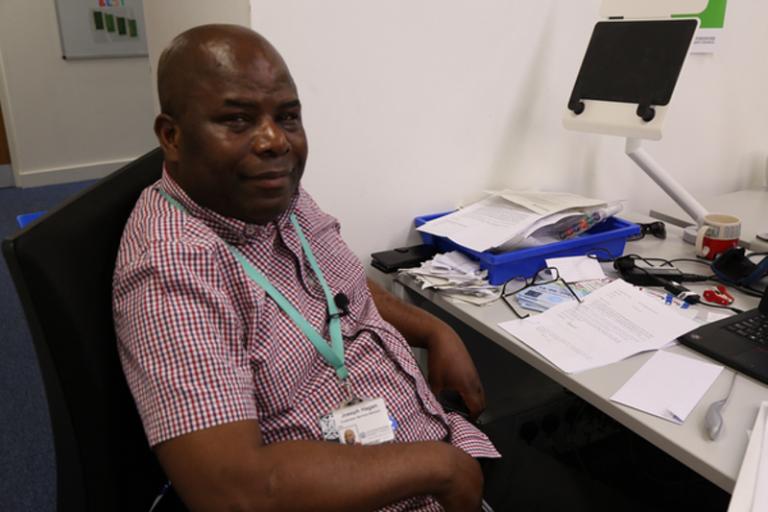 Member of staff working at his desk in customer services office.  