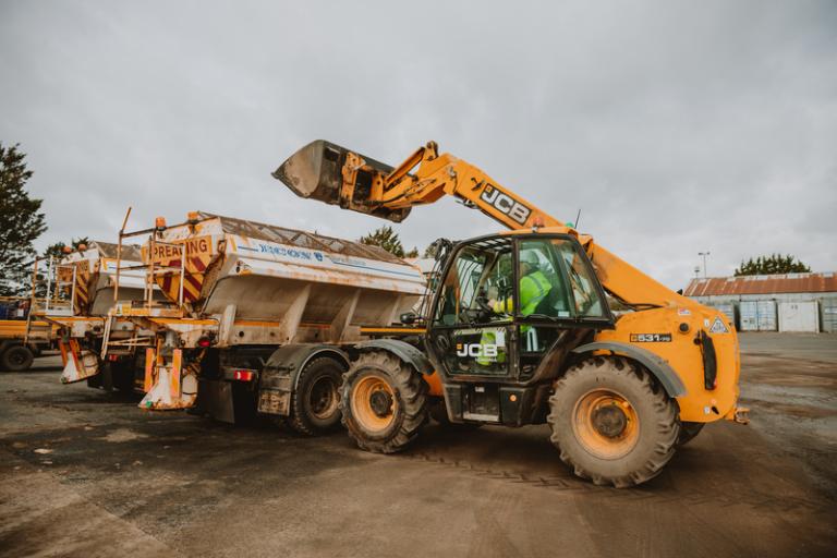 Digger vehicle loads up gritter