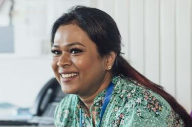 A woman smiling at someone off camera.