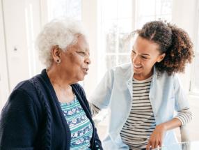 Two women in the home discuss adult social care