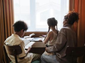 An adult and two children look at the window